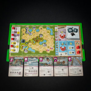 gracze przy stole układają karty zwierząt i budynków na planszy zoo Ark Nova