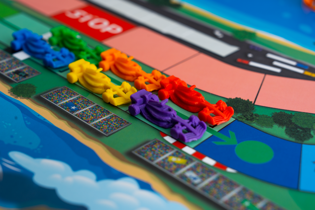 Plansza gry Formuła 1 z torami zakrętów i bolidami na starcie