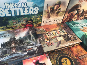 ręce układające kolorowe karty i pionki gry planszowej solo na stole